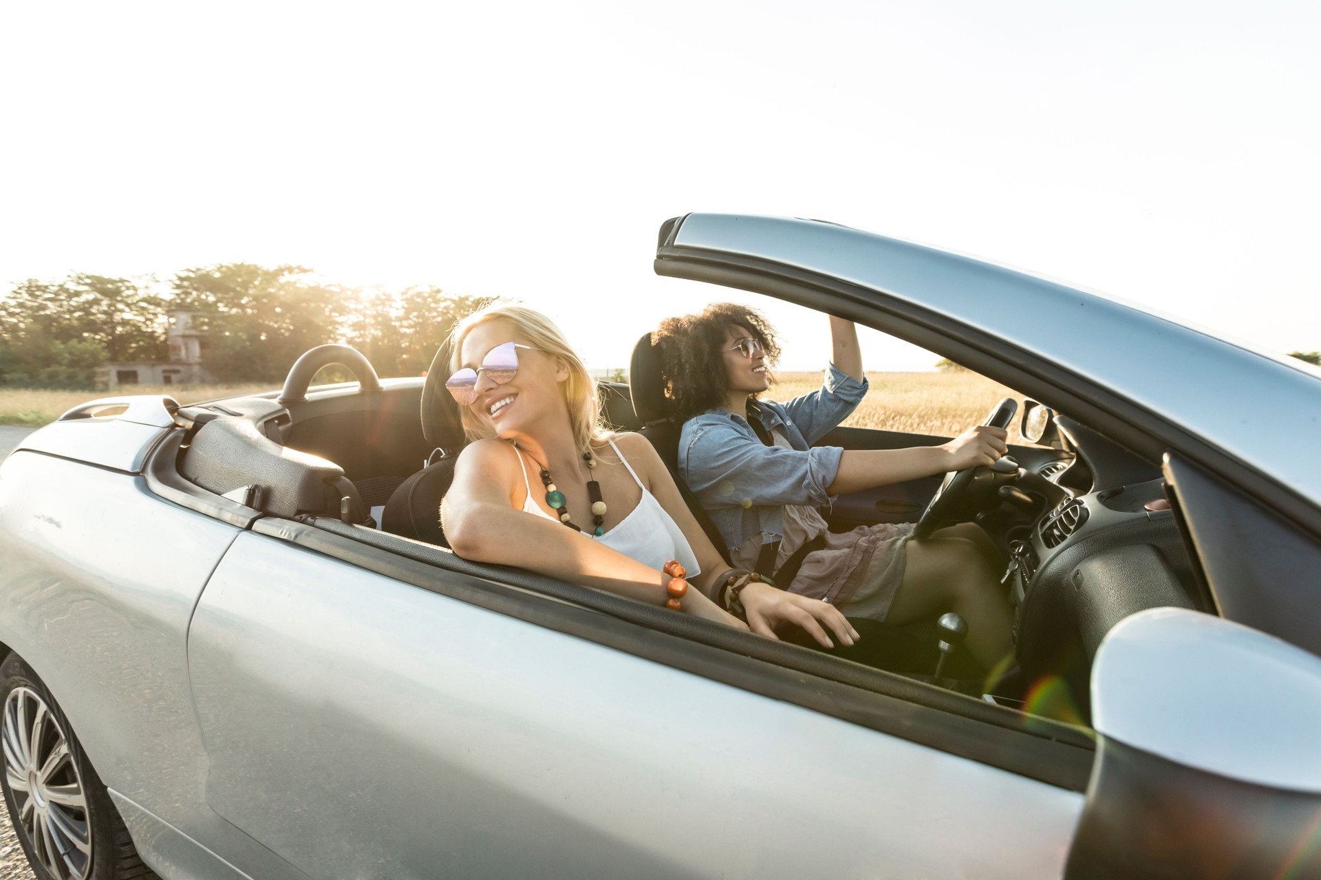 Two beautiful women traveling with cabriolet
